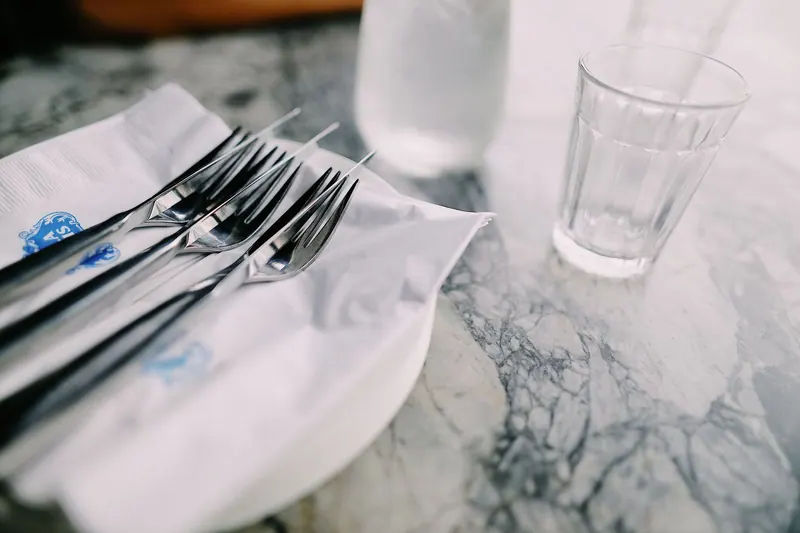 Leerer Teller und Wasserglas auf einem Tisch am Morgen